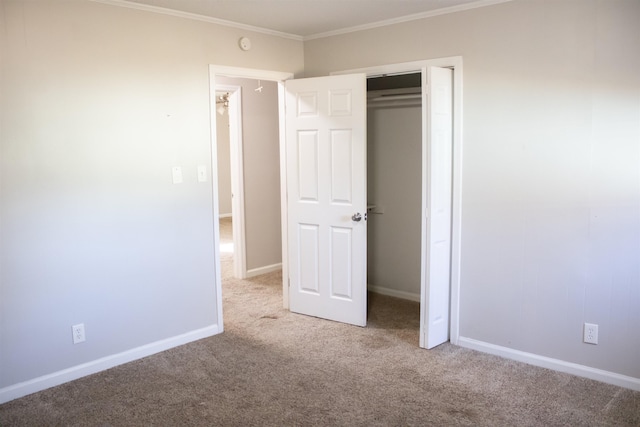 unfurnished bedroom with crown molding, carpet flooring, baseboards, and a closet