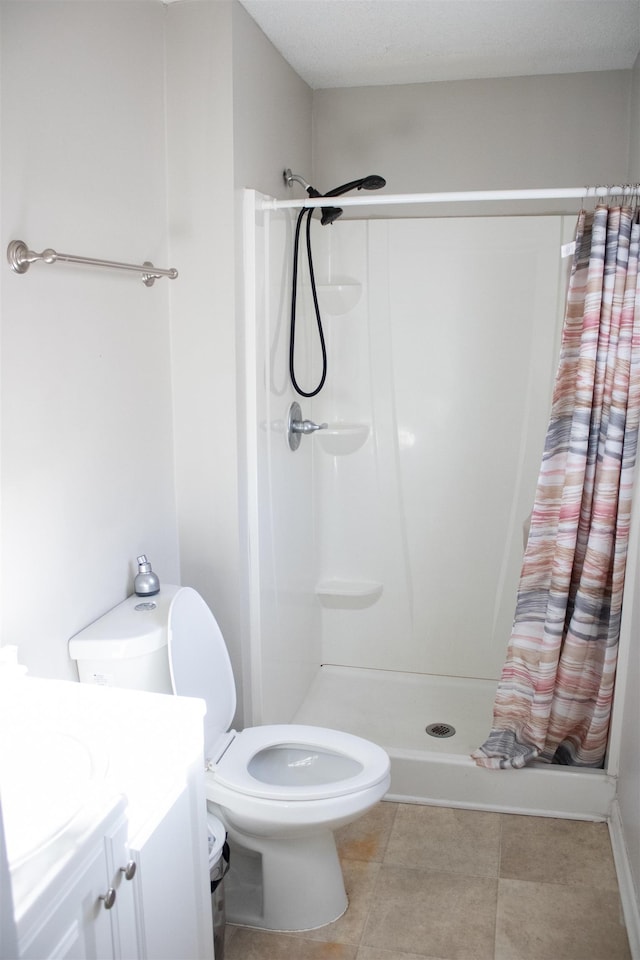 full bath featuring tile patterned floors, toilet, a stall shower, and vanity