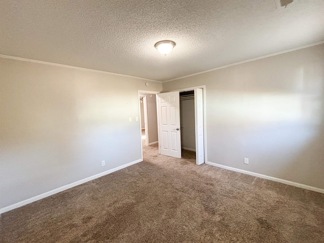 unfurnished bedroom featuring carpet, baseboards, ornamental molding, a closet, and a textured ceiling