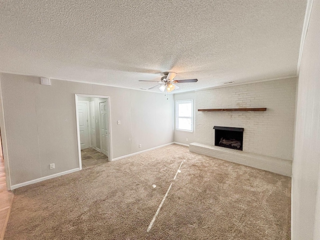 unfurnished living room with baseboards, ceiling fan, carpet flooring, a fireplace, and a textured ceiling