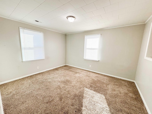 carpeted empty room featuring crown molding, baseboards, and visible vents