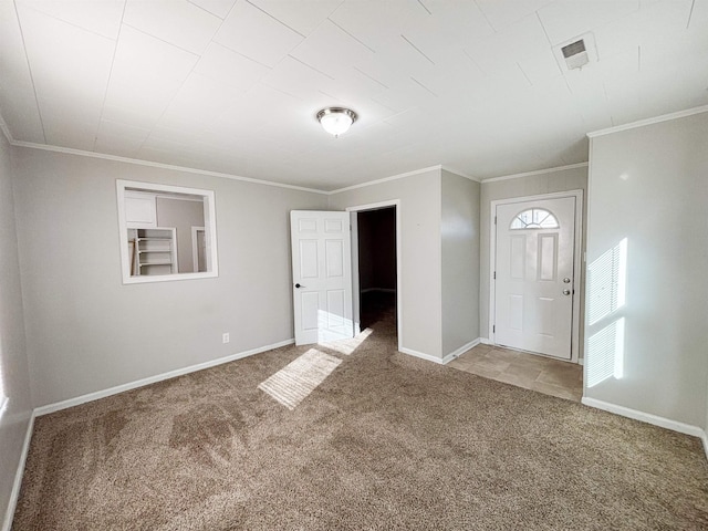 foyer with crown molding, carpet flooring, visible vents, and baseboards