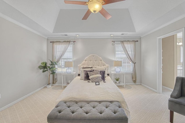 bedroom with a tray ceiling, multiple windows, light colored carpet, and baseboards