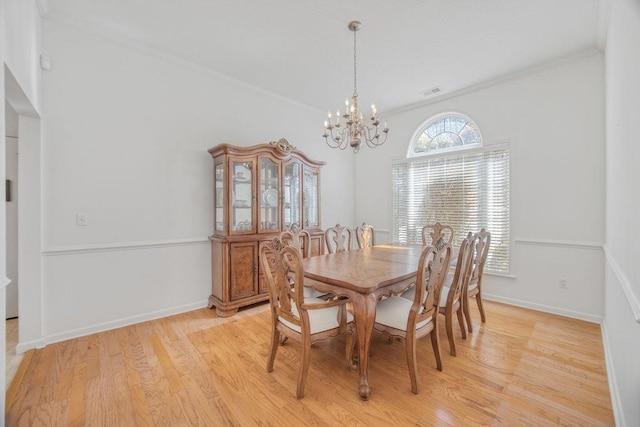 dining space featuring crown molding, a notable chandelier, light wood-style floors, and baseboards