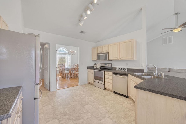 kitchen featuring visible vents, lofted ceiling, light brown cabinetry, stainless steel appliances, and dark countertops