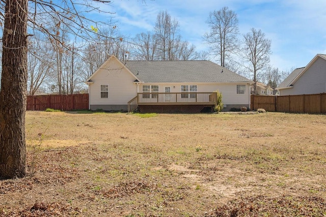 back of property featuring a lawn, a deck, and fence