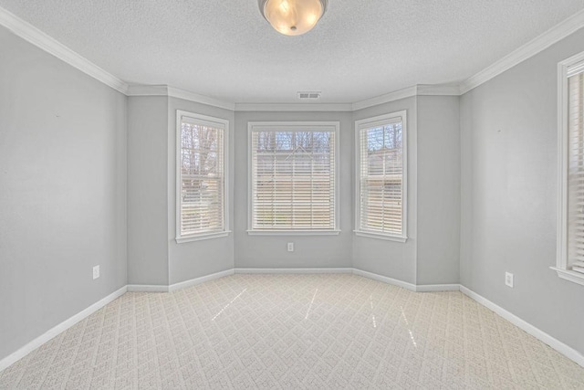 carpeted empty room with visible vents, baseboards, a textured ceiling, and ornamental molding