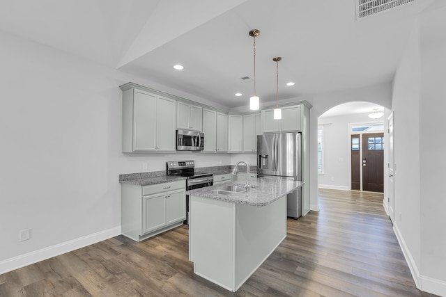 kitchen featuring visible vents, dark wood finished floors, arched walkways, a sink, and stainless steel appliances