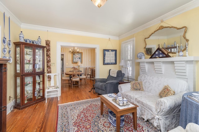 living area featuring a notable chandelier, wood finished floors, and ornamental molding