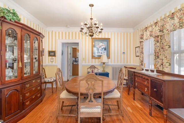 dining space with light wood-style floors, a chandelier, and wallpapered walls