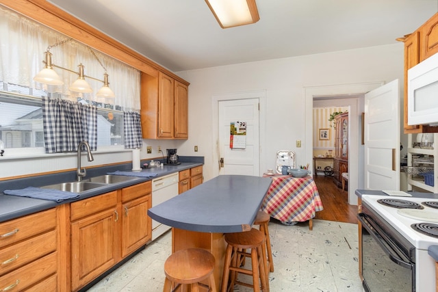 kitchen featuring dark countertops, light floors, white appliances, and a sink