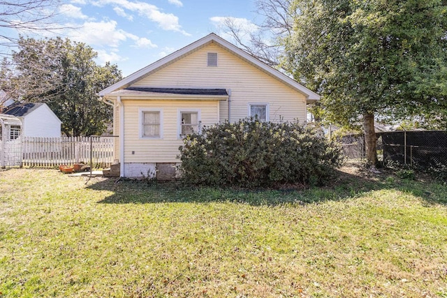 rear view of house featuring a yard and fence