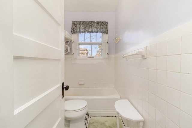 full bathroom with a tub to relax in, a wainscoted wall, walk in shower, tile walls, and toilet