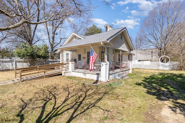 view of front of house featuring a front yard, covered porch, fence private yard, and a chimney