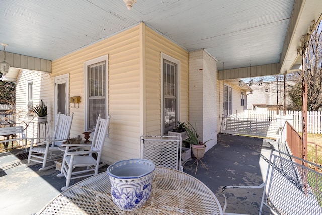 view of patio / terrace featuring covered porch and fence