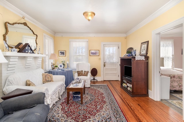 living area featuring a wealth of natural light, wood finished floors, and crown molding