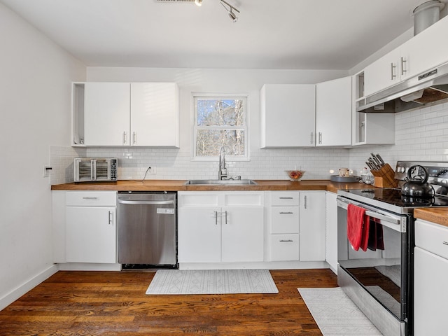 kitchen featuring dark wood-style floors, a sink, stainless steel appliances, backsplash, and butcher block counters