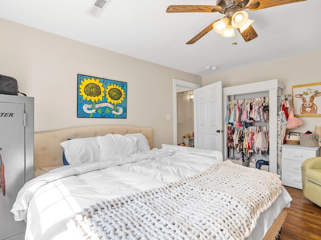 bedroom with wood finished floors, visible vents, a closet, and ceiling fan