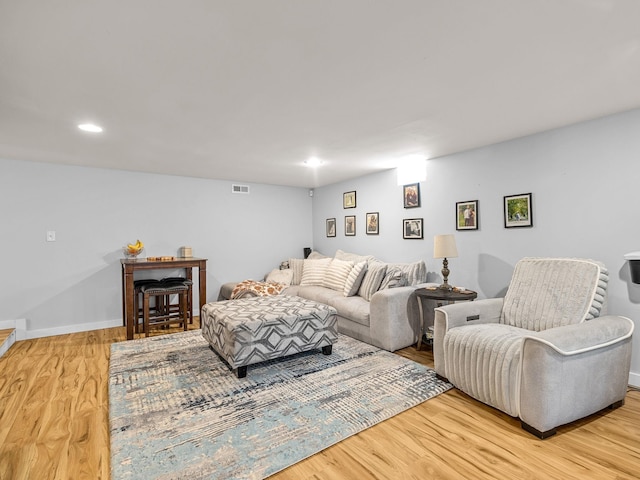 living room featuring recessed lighting, wood finished floors, visible vents, and baseboards