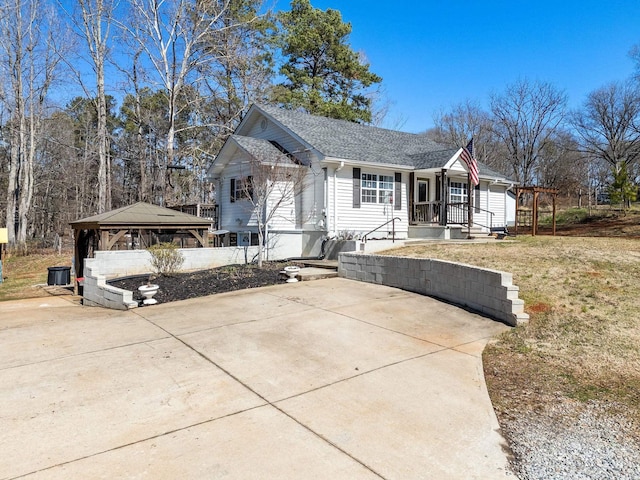 view of front of property featuring a gazebo, a front yard, driveway, and a shingled roof