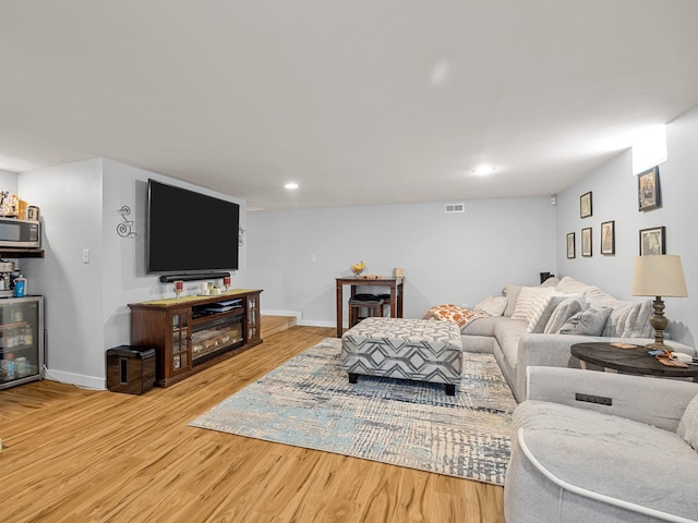 living room with recessed lighting, baseboards, wood finished floors, and beverage cooler