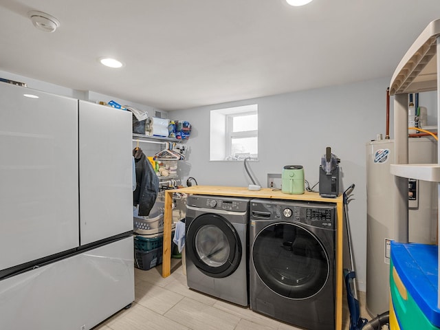 laundry area with laundry area, electric water heater, and separate washer and dryer