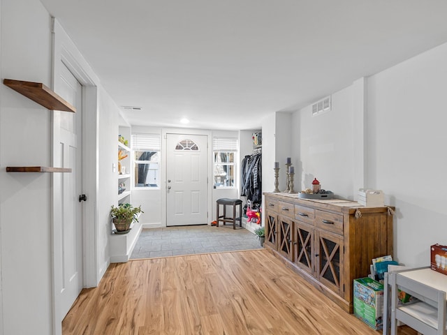 entryway with light wood-style floors and visible vents