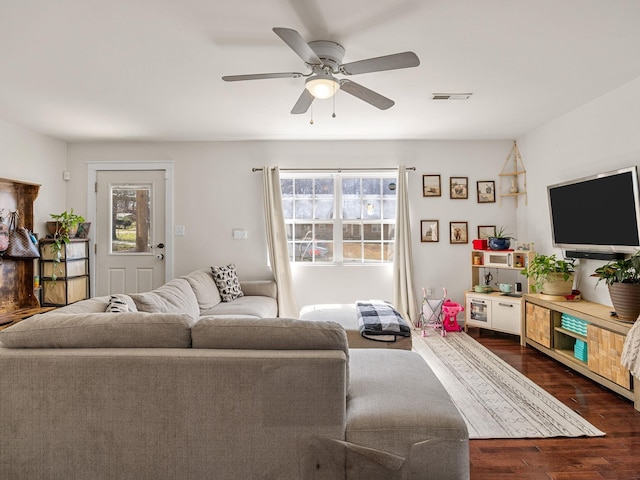 living area with visible vents, ceiling fan, and dark wood-style flooring