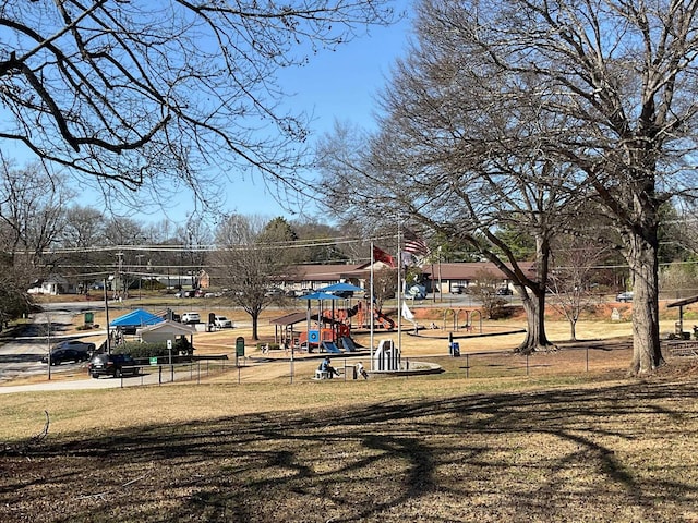 community jungle gym with a yard and fence