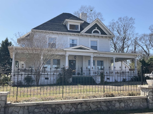 view of front facade featuring a fenced front yard, a porch, and a chimney