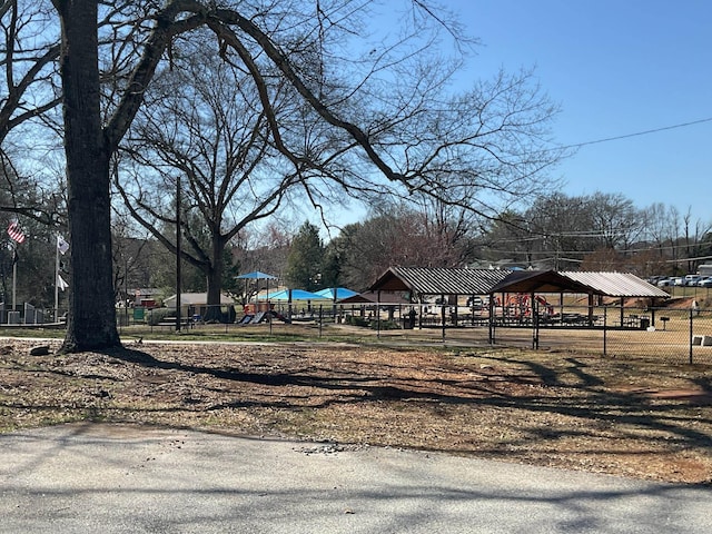 view of property's community featuring playground community and fence