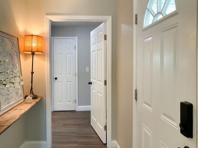 foyer with dark wood-style floors and baseboards