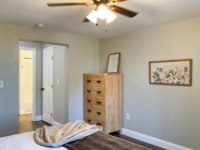 bedroom with dark wood finished floors, a ceiling fan, and baseboards