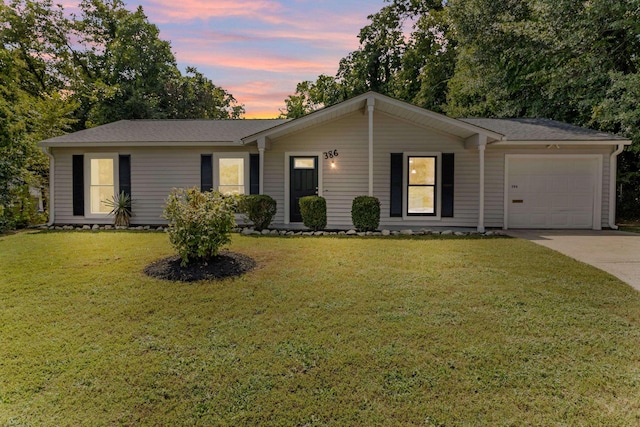 ranch-style home with a garage, a yard, and concrete driveway