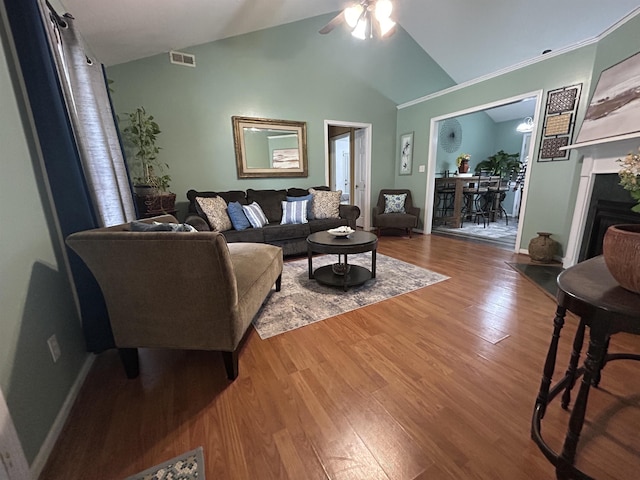 living area featuring visible vents, baseboards, wood finished floors, and a fireplace