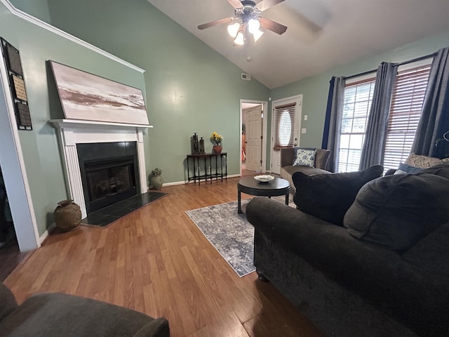 living room with wood finished floors, visible vents, baseboards, a fireplace with flush hearth, and ceiling fan