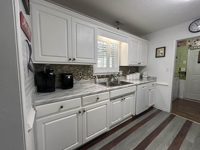 kitchen featuring dark wood finished floors, a sink, light countertops, white cabinets, and dishwasher