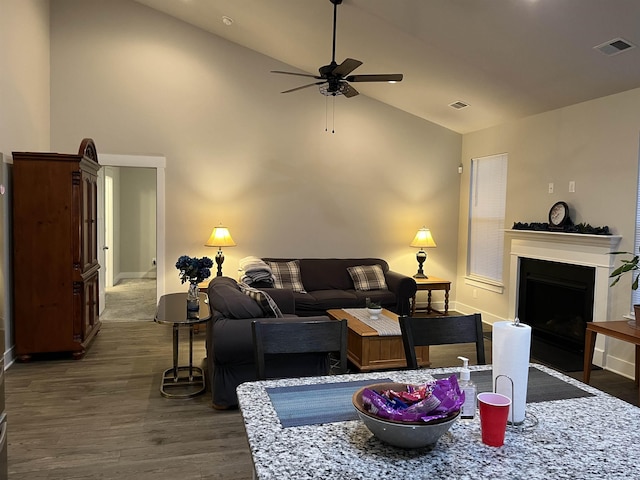 living area featuring visible vents, a fireplace, ceiling fan, and dark wood-style flooring