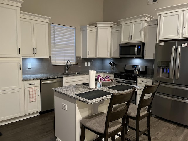 kitchen with a sink, dark wood-type flooring, white cabinets, and stainless steel appliances