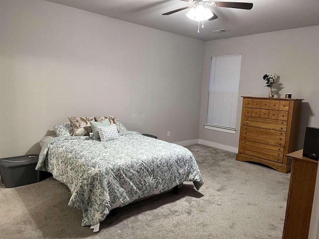 carpeted bedroom featuring visible vents, baseboards, and a ceiling fan