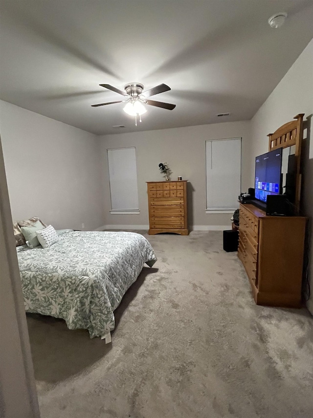 bedroom featuring light colored carpet, baseboards, and ceiling fan