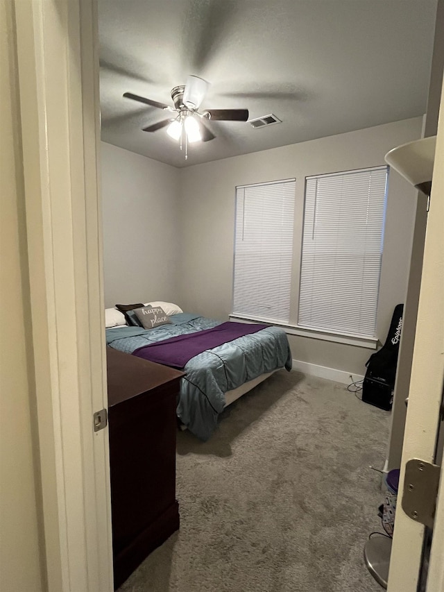 carpeted bedroom featuring visible vents, baseboards, and a ceiling fan