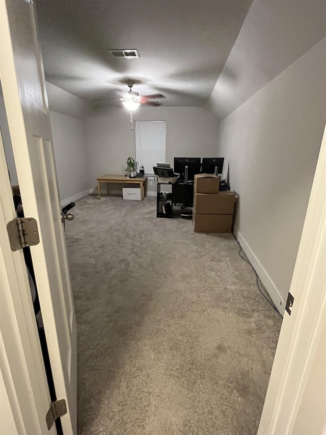 carpeted home office with visible vents, baseboards, lofted ceiling, and ceiling fan