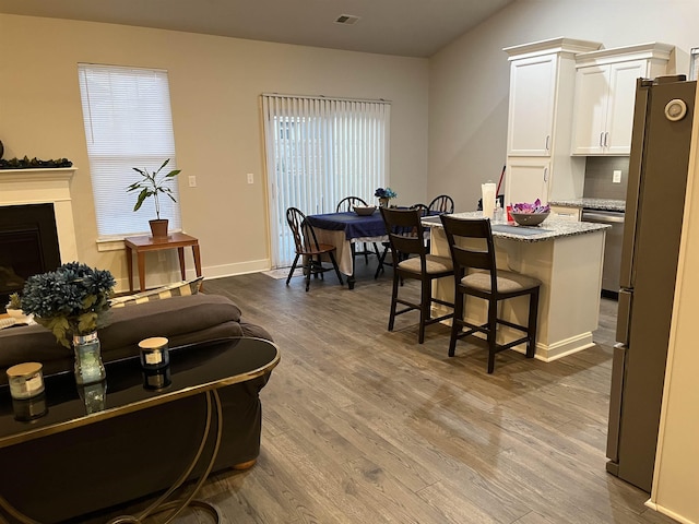 interior space with a wealth of natural light, visible vents, wood finished floors, and a fireplace