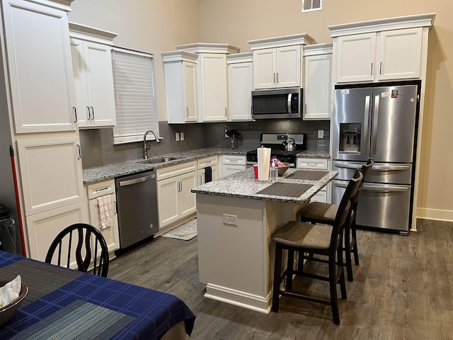 kitchen featuring a sink, dark wood-style floors, tasteful backsplash, and stainless steel appliances