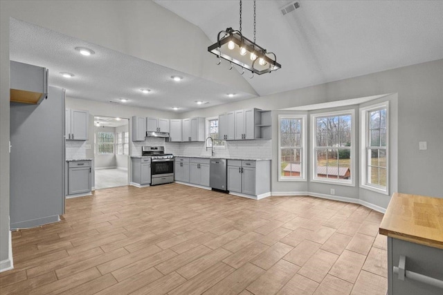 kitchen with visible vents, under cabinet range hood, gray cabinets, appliances with stainless steel finishes, and open shelves