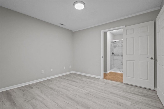 unfurnished bedroom featuring visible vents, light wood-style flooring, connected bathroom, and baseboards