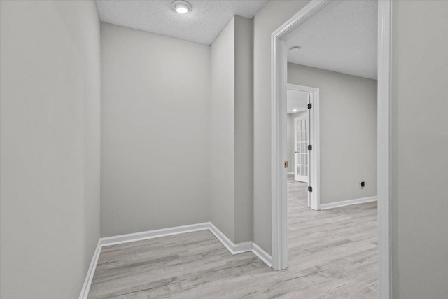 corridor with wood finished floors and baseboards