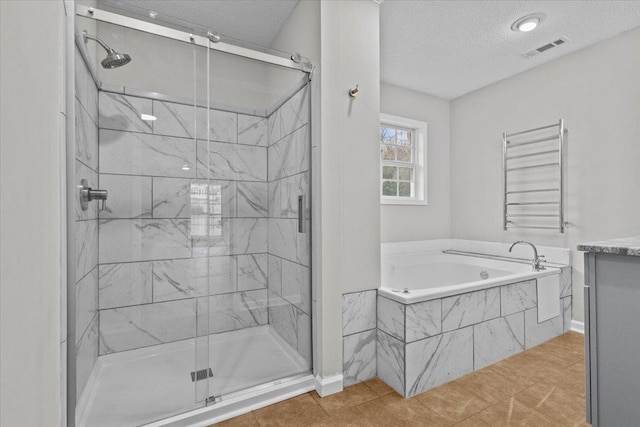 bathroom featuring visible vents, radiator heating unit, a stall shower, a textured ceiling, and a bath