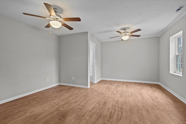 unfurnished room with a ceiling fan, baseboards, visible vents, light wood finished floors, and a textured ceiling